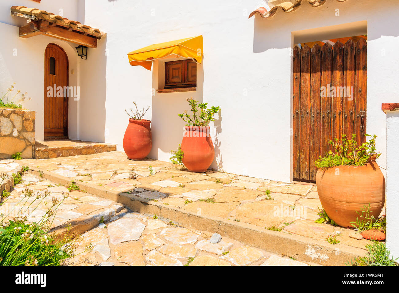Blumentöpfe vor typischen weißen Haus in Sa Tuna Küsten Fischerdorf, Costa Brava, Spanien Stockfoto