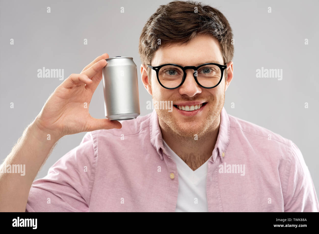 Glückliche junge Mann Zinn Holding kann mit Soda Stockfoto