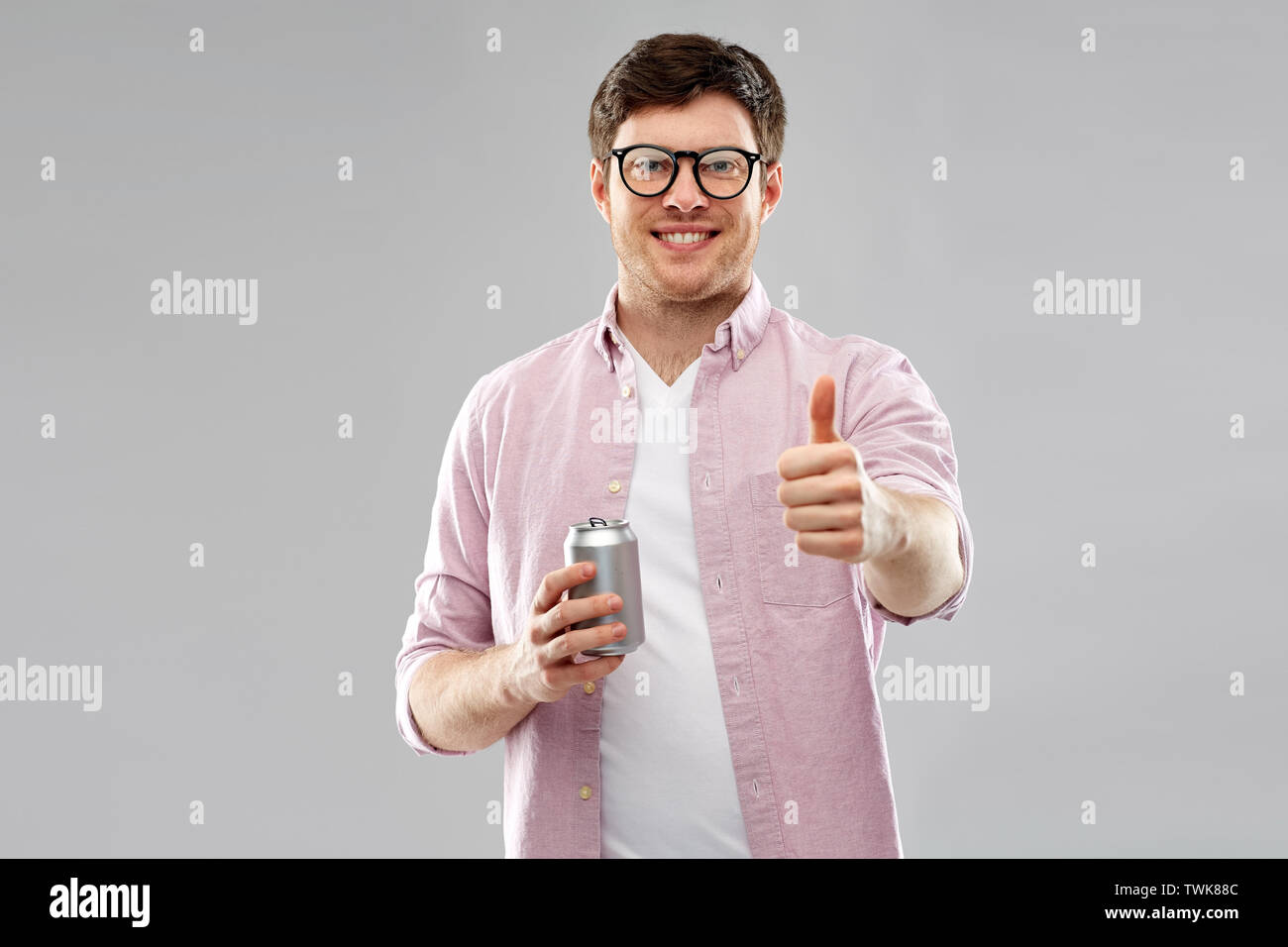 Glückliche Menschen mit Soda in Blechdose mit Daumen hoch Stockfoto