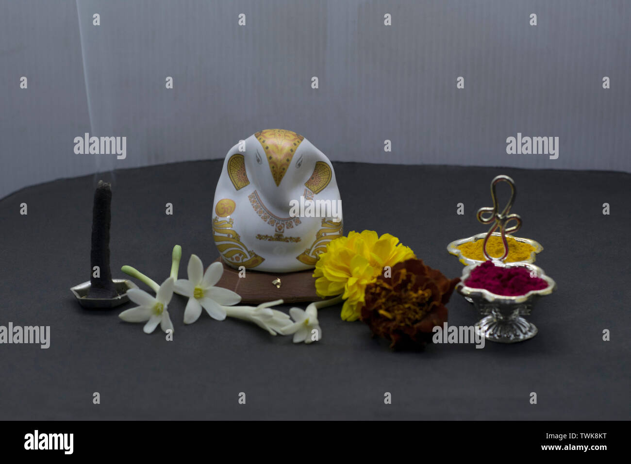 Ganesha mit Blumen und Räucherstäbchen. Stockfoto