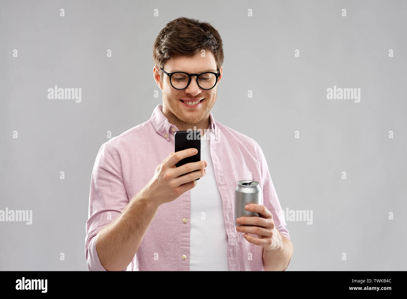 Junge Mann in Gläsern mit Smartphone und Trinken Stockfoto