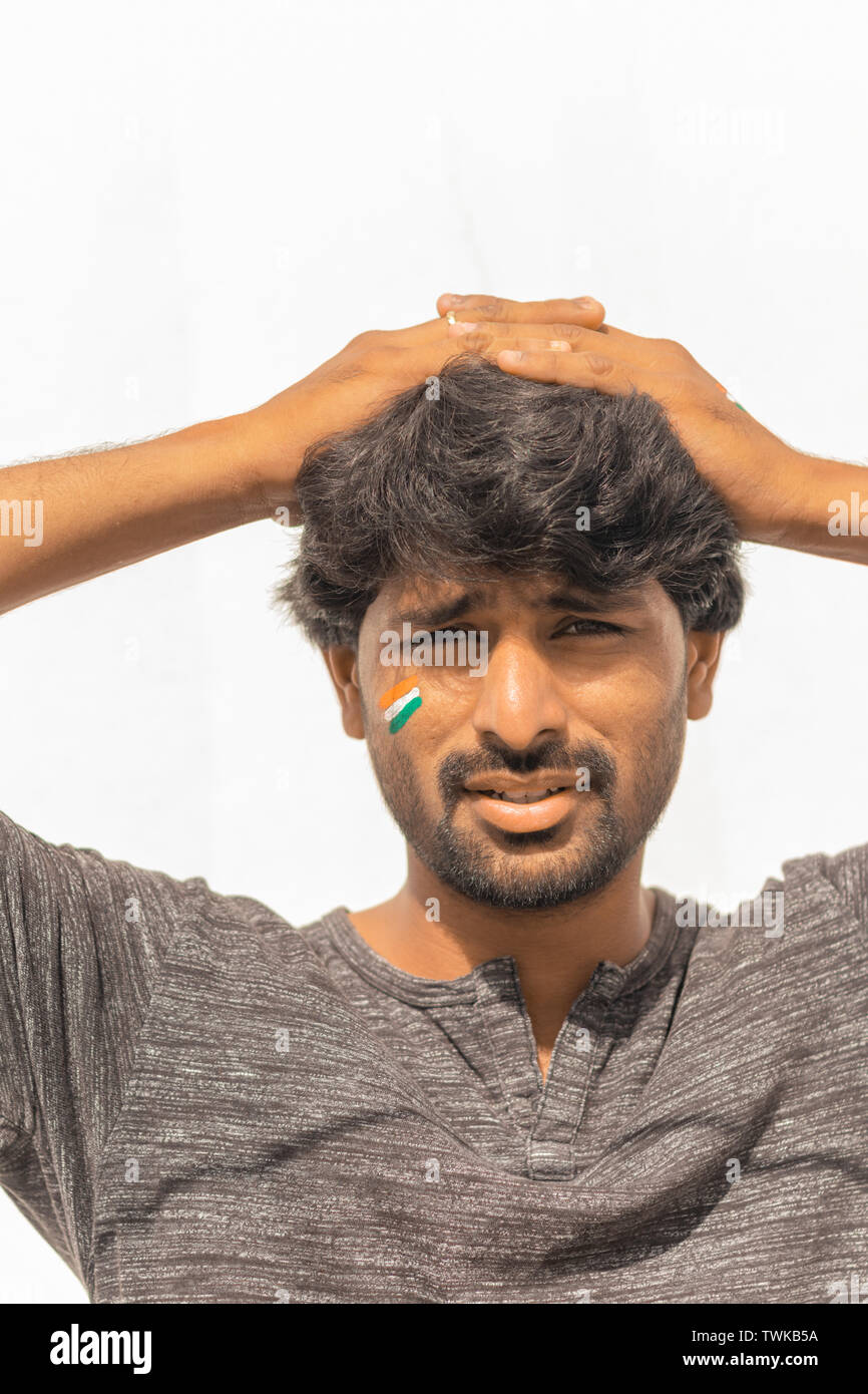 Portrait von neugierig oder angespannt Jungen Indischen männlichen Cricket Sport lackiert indische Flagge auf seinem Gesicht Stockfoto
