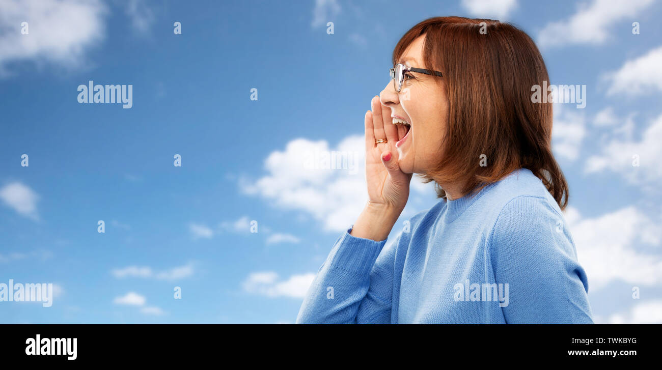 Ältere Frau in Gläser Aufruf über das Sky Stockfoto