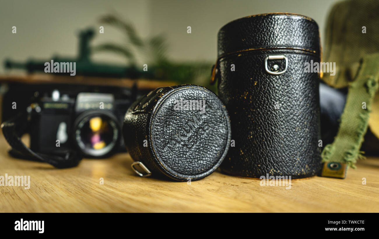 Alt, Vintage, retro style Takumar Objektivabdeckung Kisten und Pentax Spotmatic Kamera im Hintergrund auf hölzernen Tisch Stockfoto