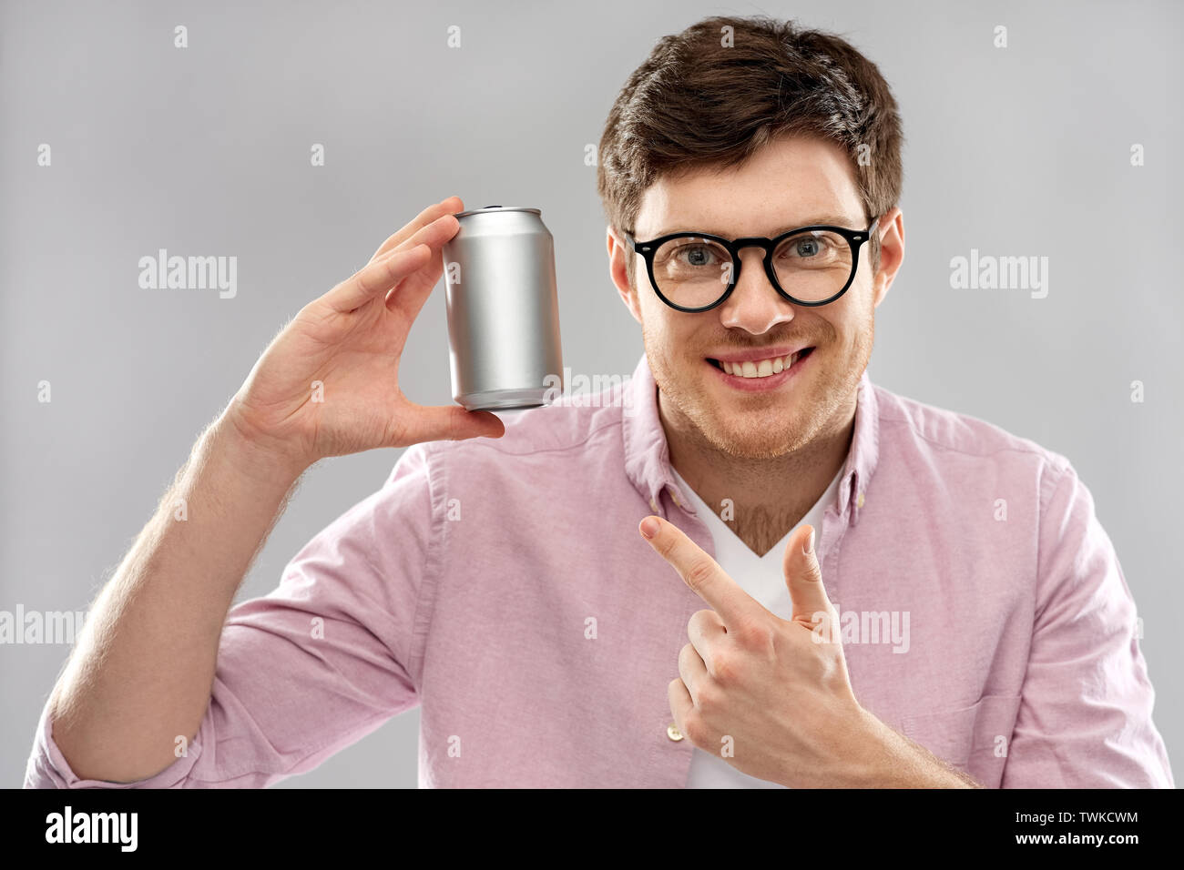 Glückliche junge Mann Zinn Holding kann mit Soda Stockfoto