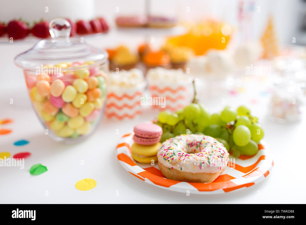 Trauben, Macarons und Krapfen auf Party Tabelle Stockfoto