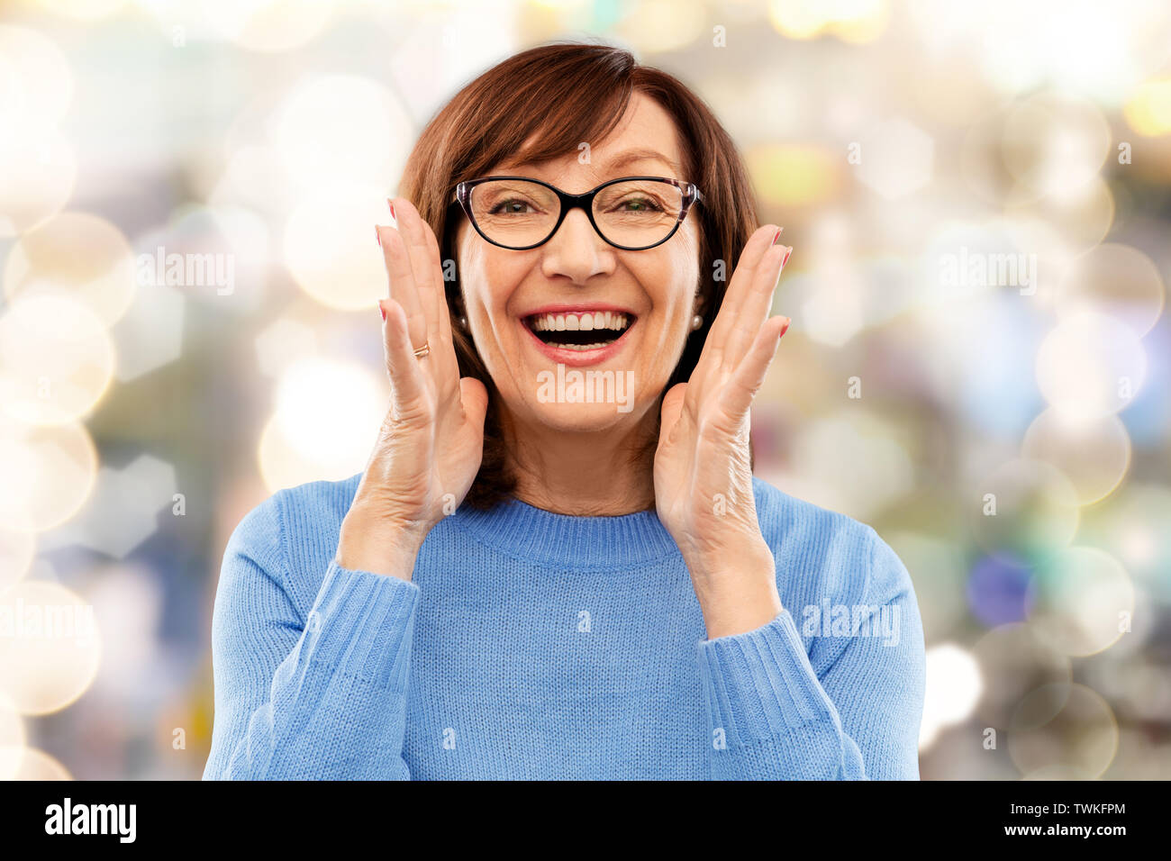 Ältere Frau in Gläser Aufruf über Grau Stockfoto