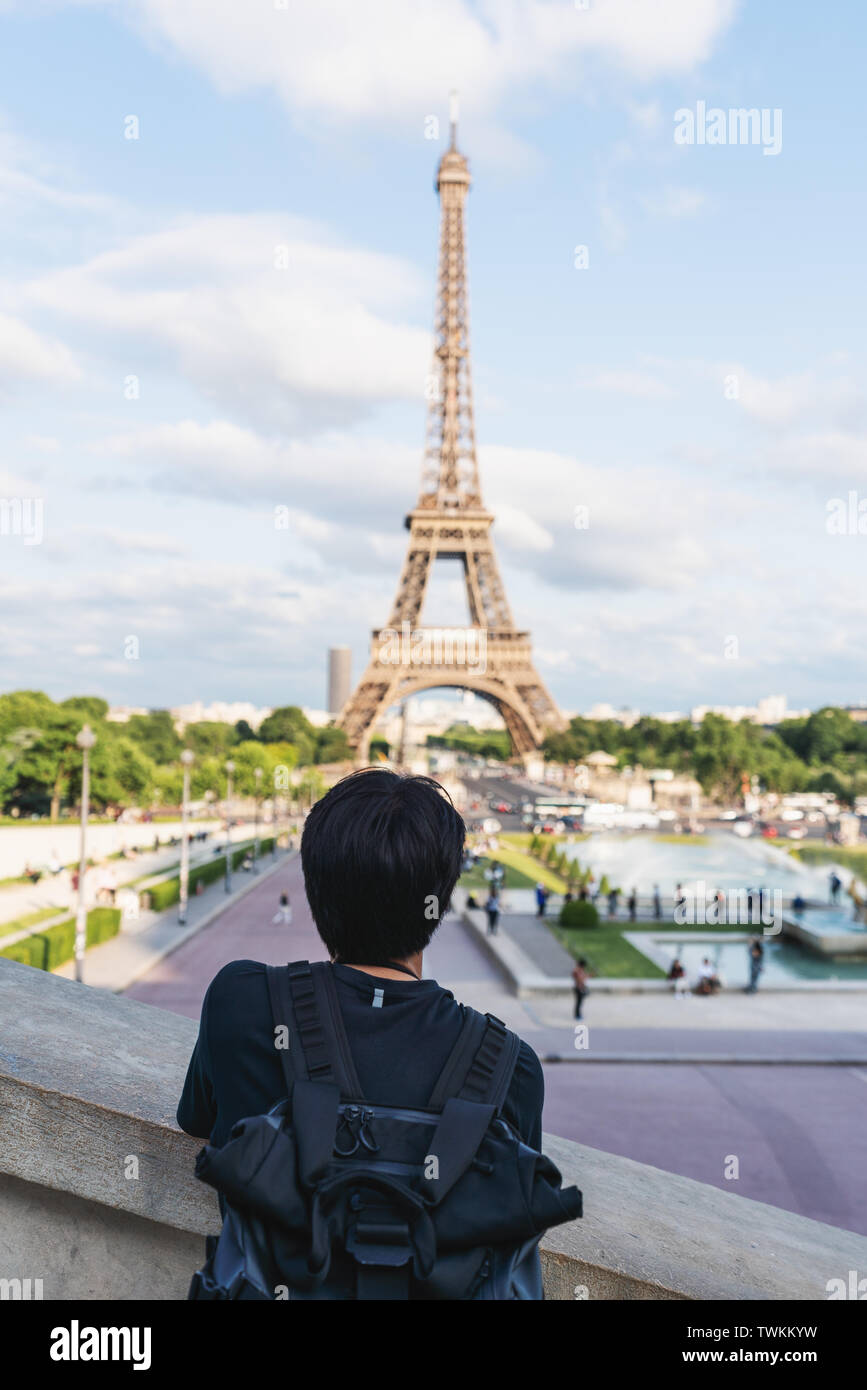 Ein Mann mit Rucksack am Eiffelturm suchen, Wahrzeichen und Reiseziel in Paris, Frankreich. Unterwegs in Europa im Sommer Stockfoto