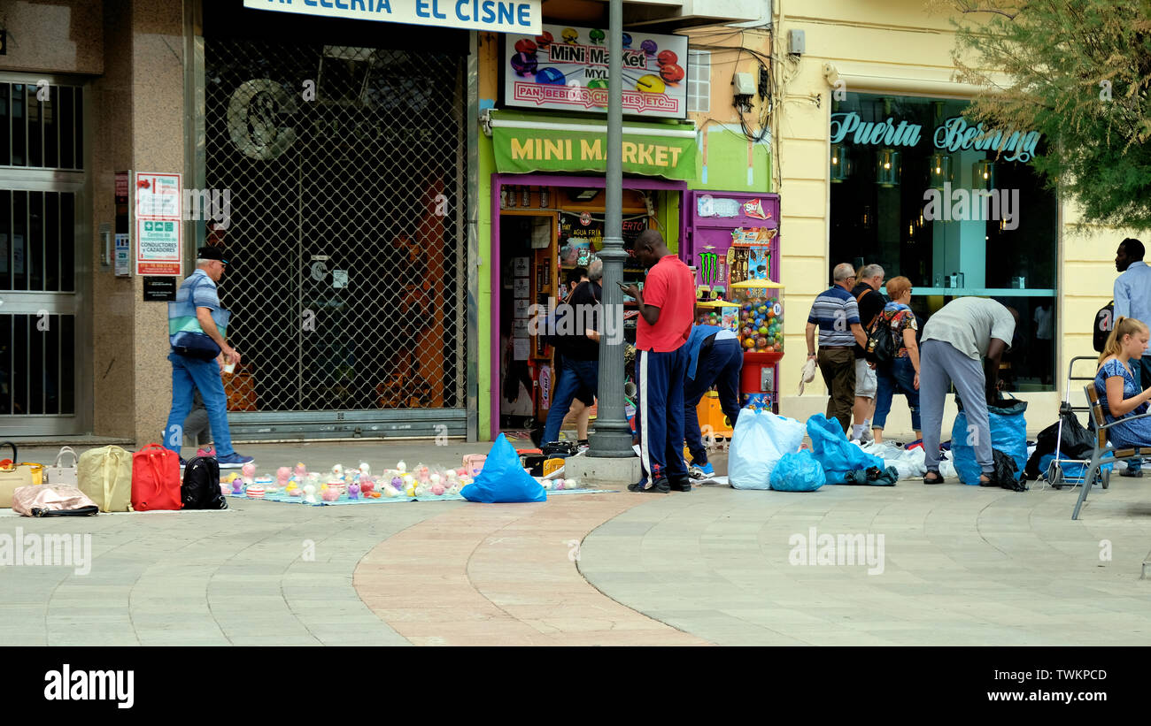 Eingewanderten Straßenhändlern in Granada, Spanien; informelle Wirtschaft, illegale Bürgersteig Anbieter mit Merchandise für potenzielle Kunden oder Kunden angezeigt. Stockfoto