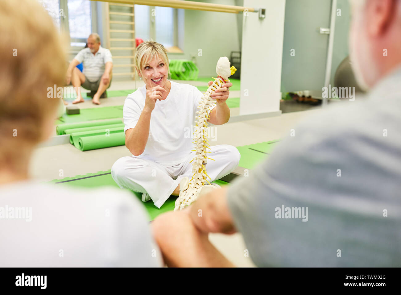 Physiotherapeutin mit wirbelsäule Modell in einer Rückenschule für Senioren im rehab Stockfoto
