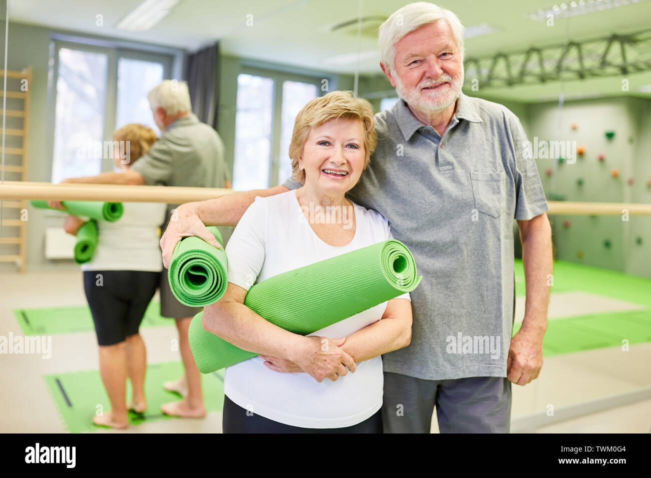 Gerne sportliche Senioren Paar mit Yoga Matte in der Turnhalle oder im Fitnesscenter Stockfoto
