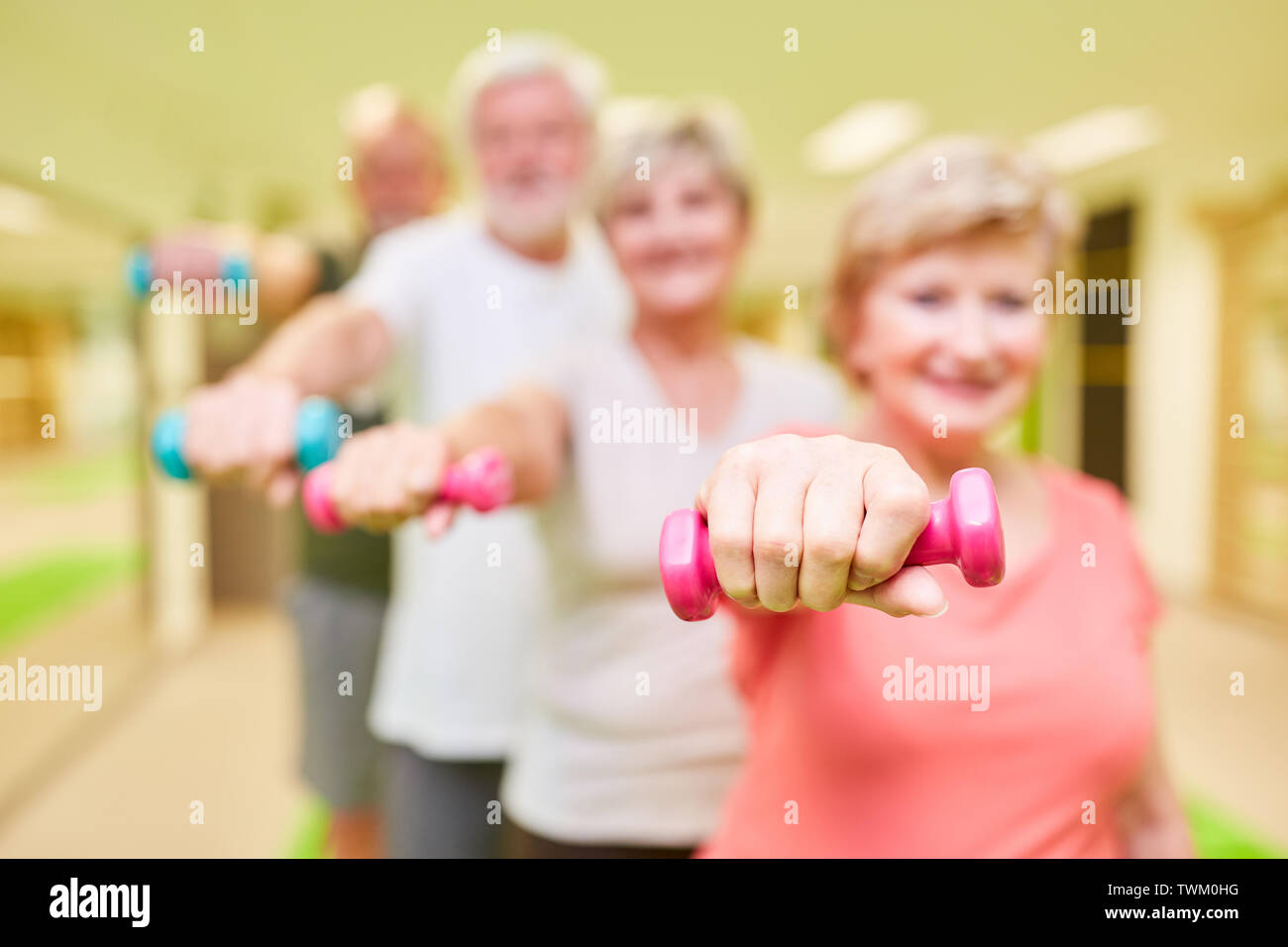 Gruppe von Senioren in der Reha und Physiotherapie während Krafttraining mit Hanteln Stockfoto