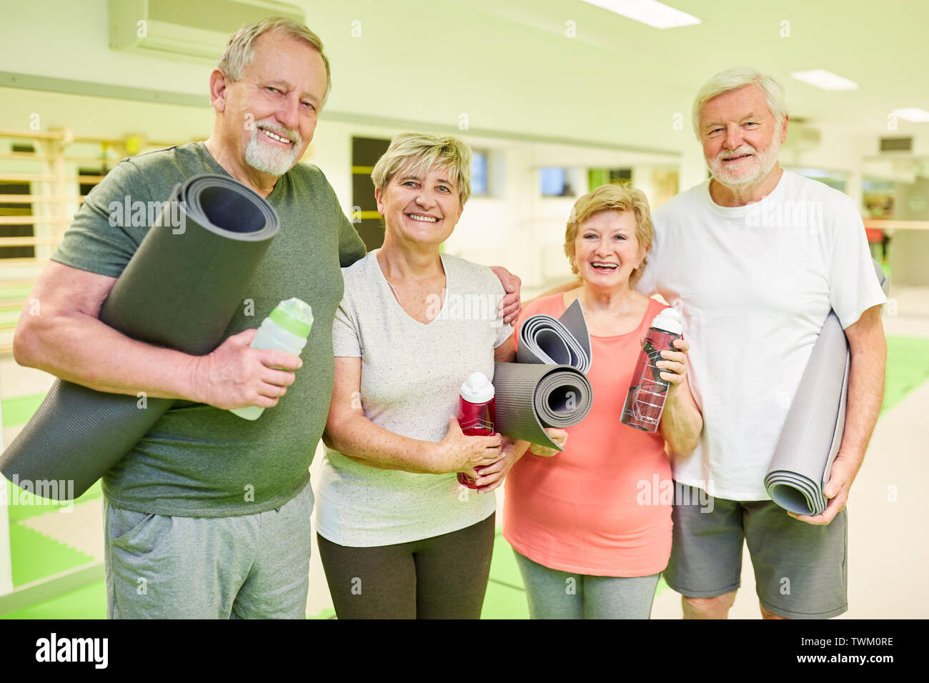 Fröhliche Senioren Gruppe mit Yoga Matte in einer Pause in der Turnhalle nach der Rehabilitation Sport Stockfoto