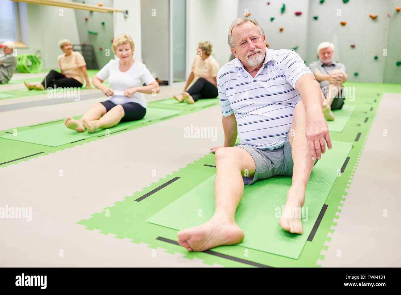 Gruppe von Senioren auf Yoga Matten an der Rehabilitation, Sport in der Physiotherapie Klasse im Pilates Studio Stockfoto