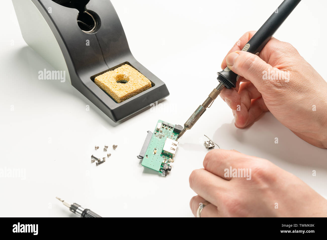 Ein Techniker Löten ein elektronisches Bauteil mit einem Lötkolben Stockfoto