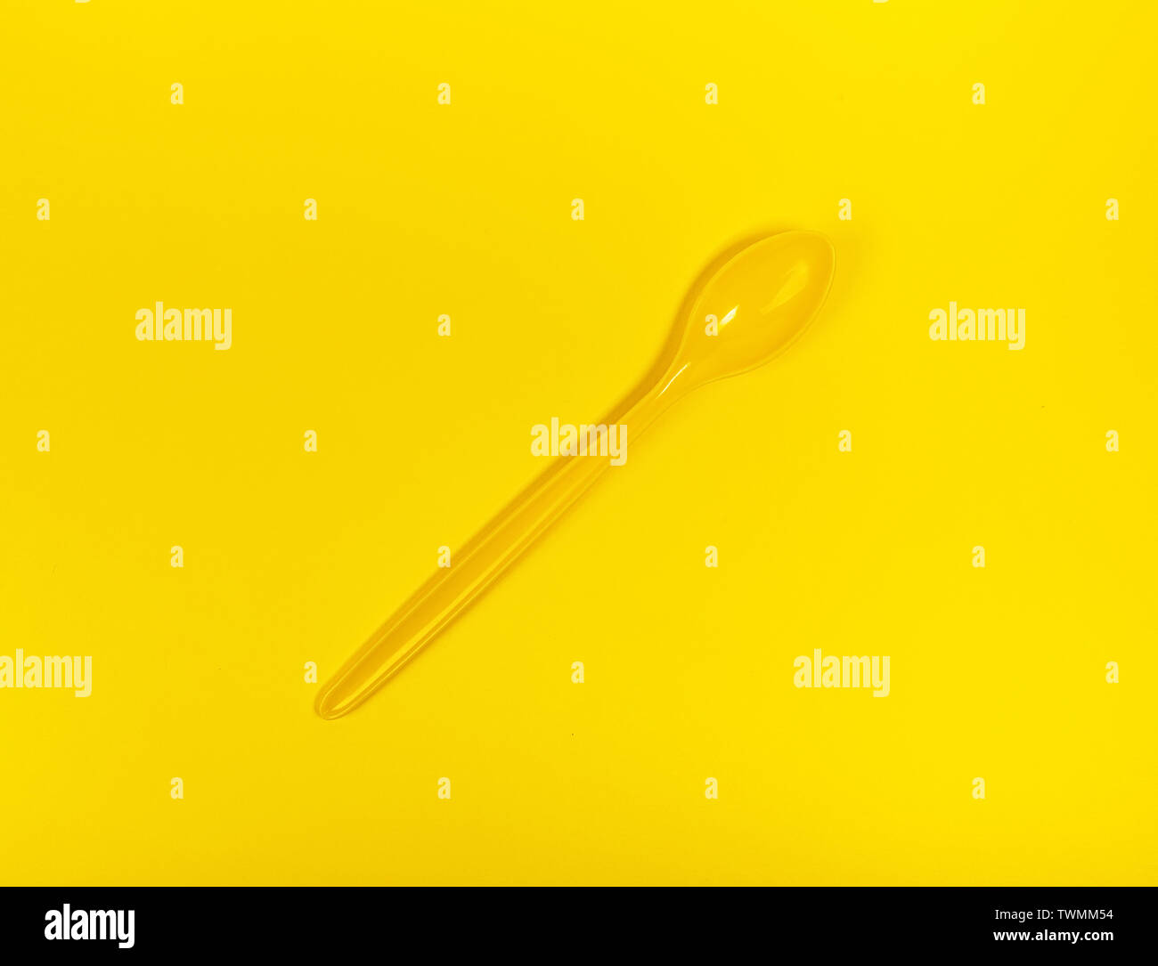 Große gelbe Löffel für Essen auf gelben Hintergrund. Gleiche Farbe Konzept. Stockfoto