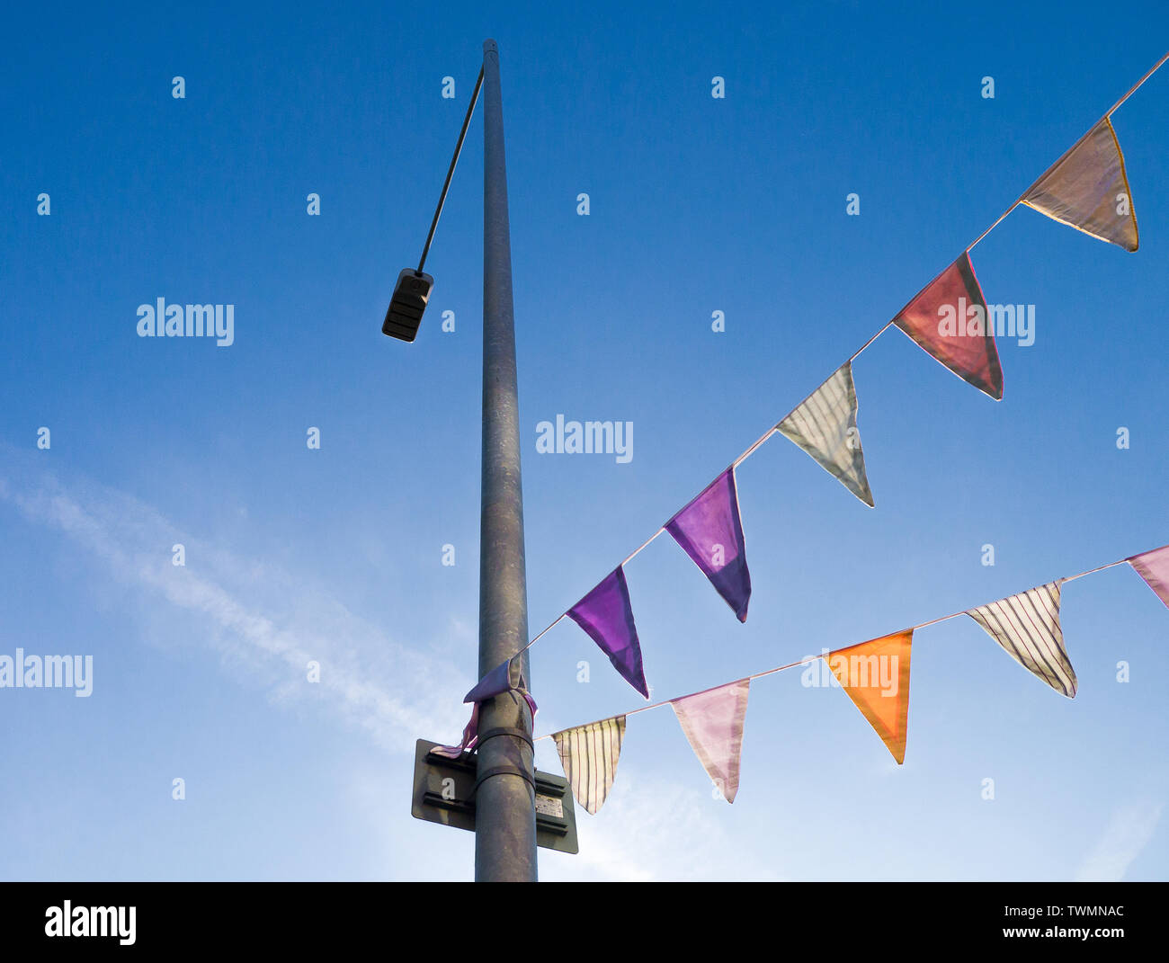 Farbe Bild von BUNTING an einen Laternenpfahl, geschossen von unten gegen den blauen Himmel Stockfoto