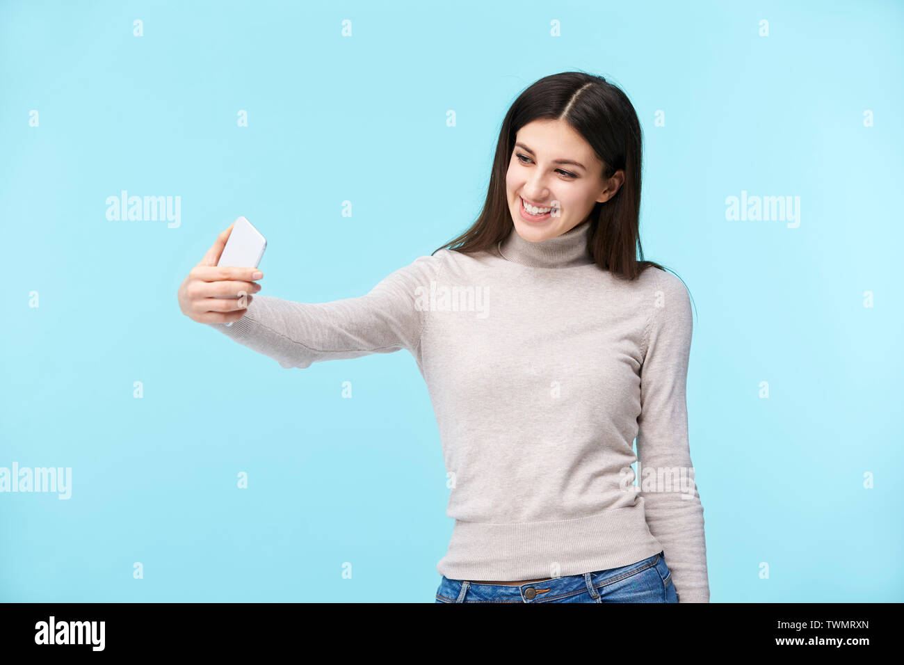 Schönen jungen kaukasischen Frau eine selfie, glücklich und lächelnd, auf blauem Hintergrund isoliert Stockfoto