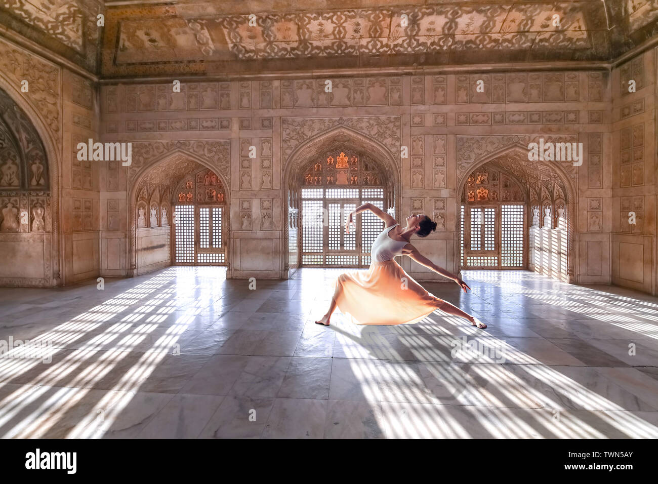 Weibliche Touristen posieren als Balletttänzer in Agra Fort Royal Palace mit filigranen weißen Marmor Wand Art. Agra Fort ist ein UNESCO-Weltkulturerbe. Stockfoto