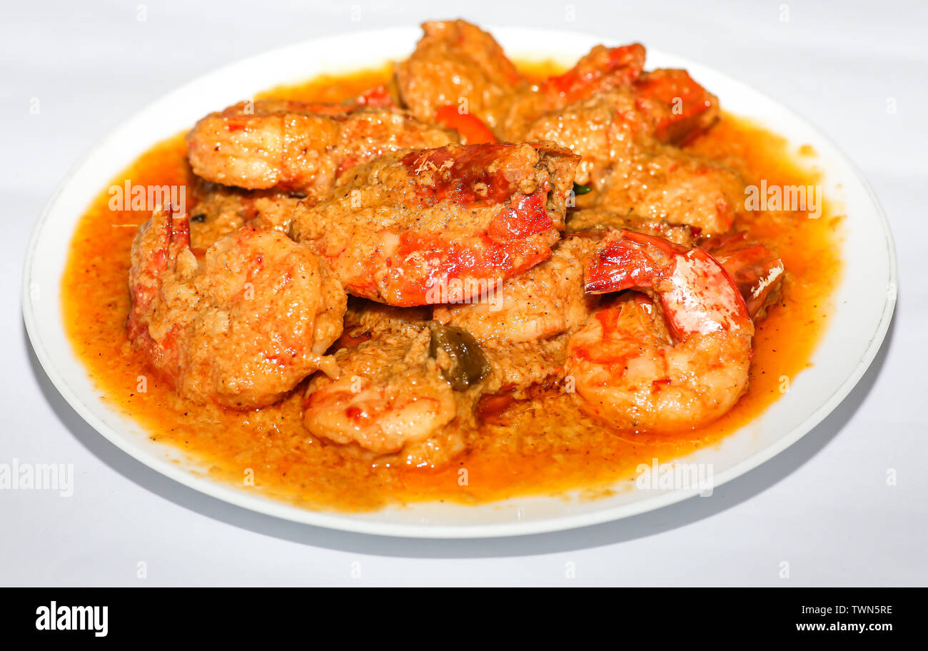 Indische scharfes Essen Garnelen Curry zubereitet mit Kokosnuss als Beilage mit Reis auf weißem Hintergrund serviert. Stockfoto