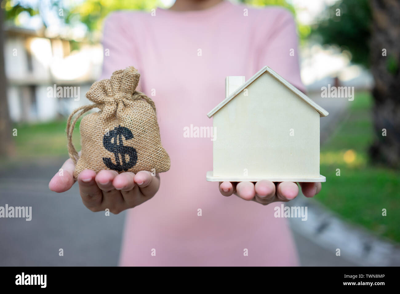 Ein Modell Haus Modell ist auf die Hände des Geschäfts in Asien Mädchen gelegt. Als Hintergrund Geschäftskonzept und Immobilien konzept mit Platz für Sie kopieren Stockfoto