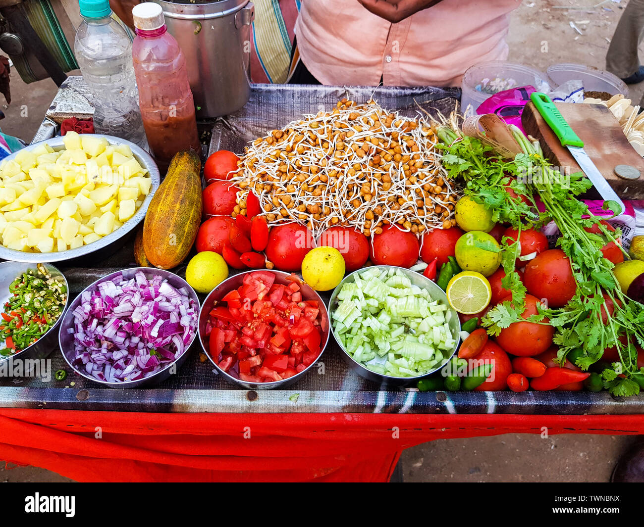 Indische Street Food vendor verkaufen würzige Kichererbsen Bengal Gramm chole Mischung garniert mit frisch geschnittenen Zwiebel, Gurke chili und Tomate Stockfoto