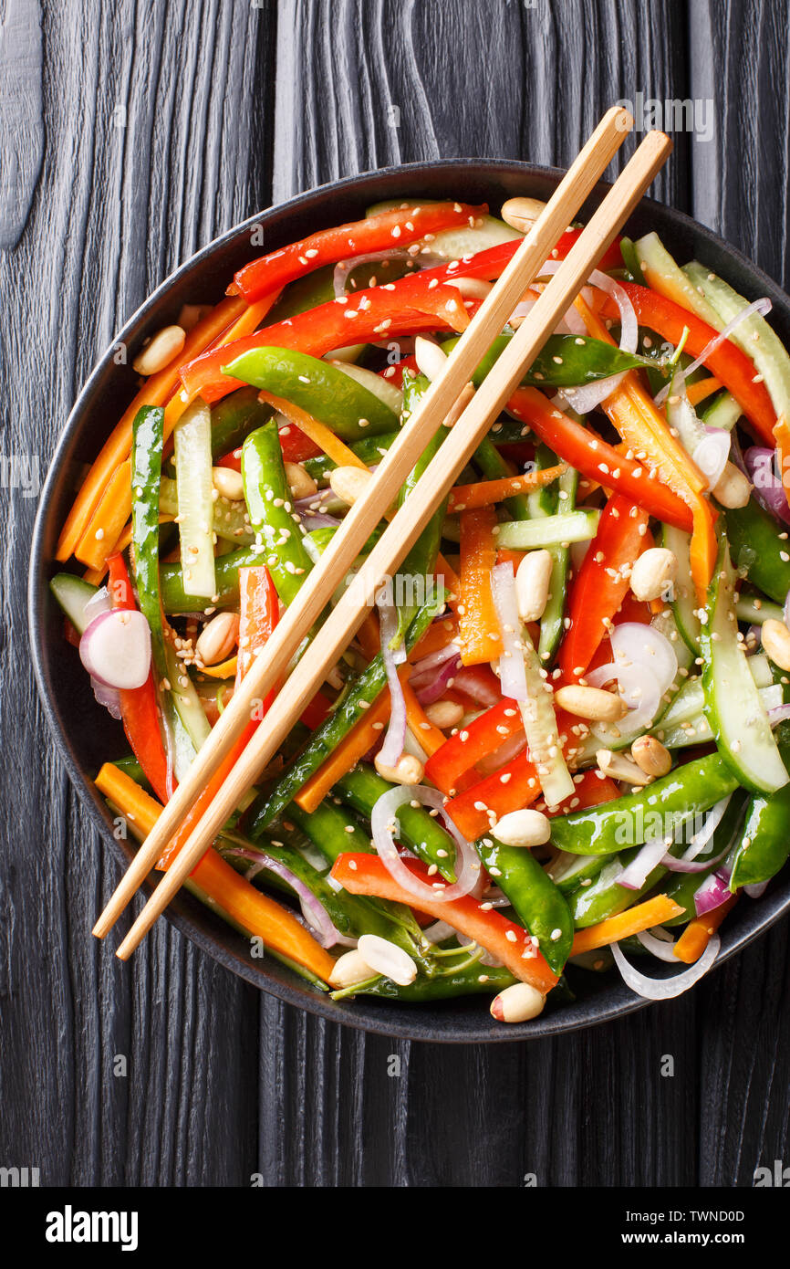 Chinesische frisches Gemüse Salat mit Sesam und Erdnüsse close-up auf einem Teller auf den Tisch. Vertikal oben Ansicht von oben Stockfoto