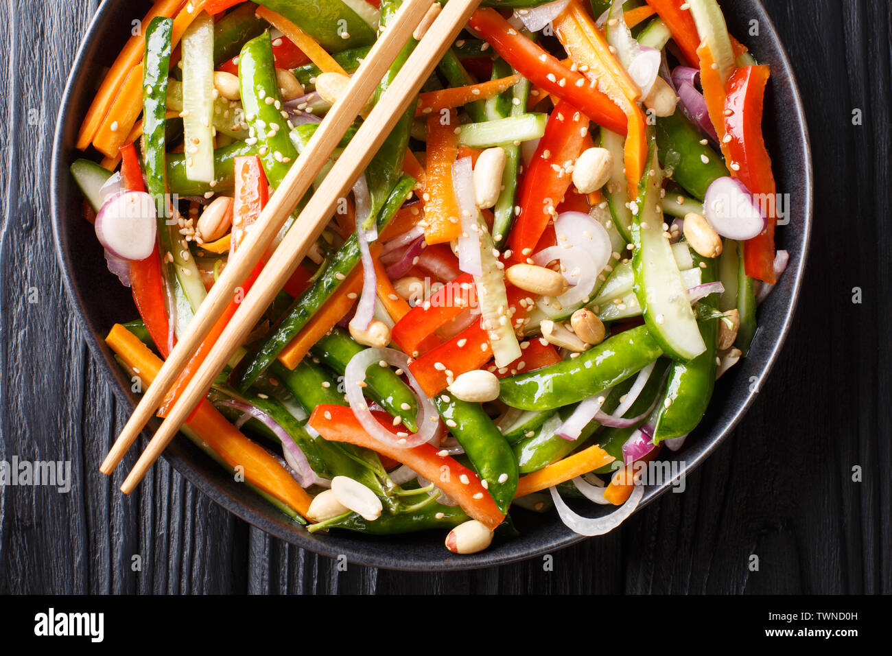 Chinesische frisches Gemüse Salat mit Sesam und Erdnüsse close-up auf einem Teller auf den Tisch. Horizontal oben Ansicht von oben Stockfoto