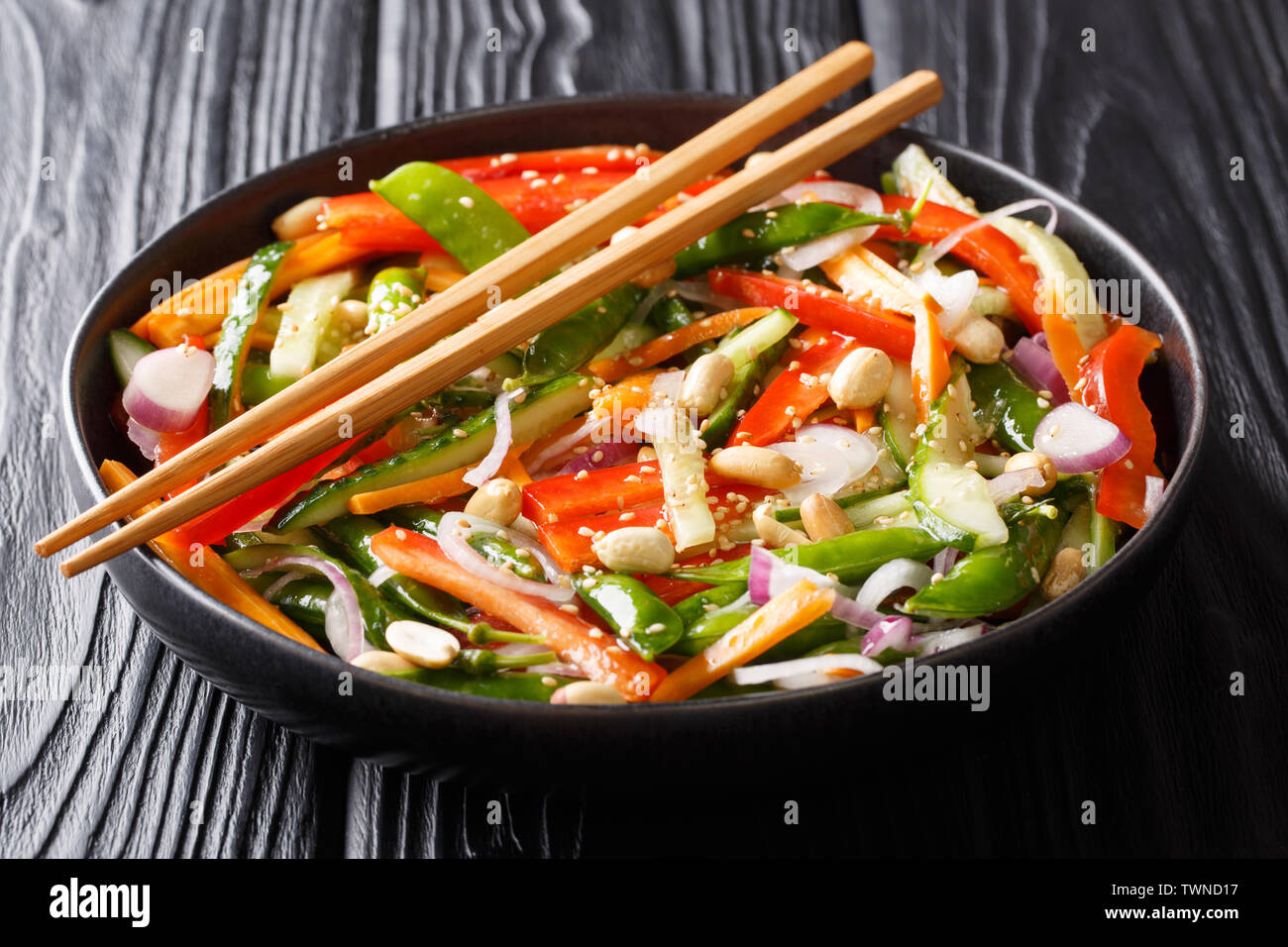 Gesunde gemüse salat mit Sesam und Erdnüsse close-up auf einem Teller auf den Tisch. Im asiatischen Stil. Horizontale Stockfoto