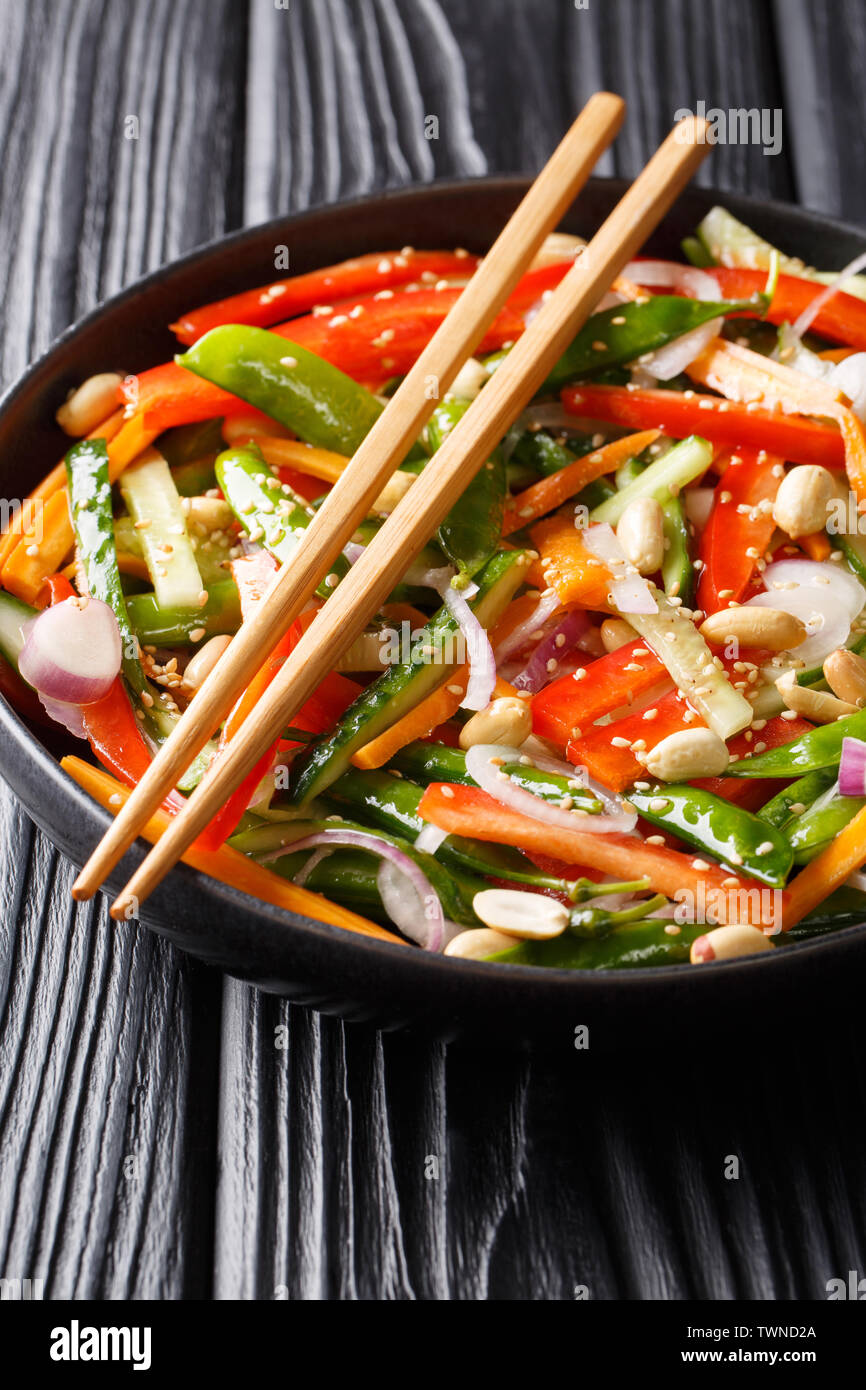 Chinesische frisches Gemüse Salat mit Sesam und Erdnüsse close-up auf einem Teller auf den Tisch. Vertikale Stockfoto