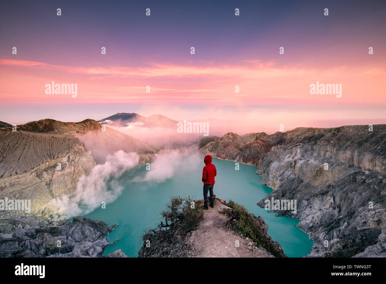 Mann stand am Rand des Kraters mit bunten Himmel am Morgen. Kawah Ijen Vulkan, Ost Java, Indonesien Stockfoto