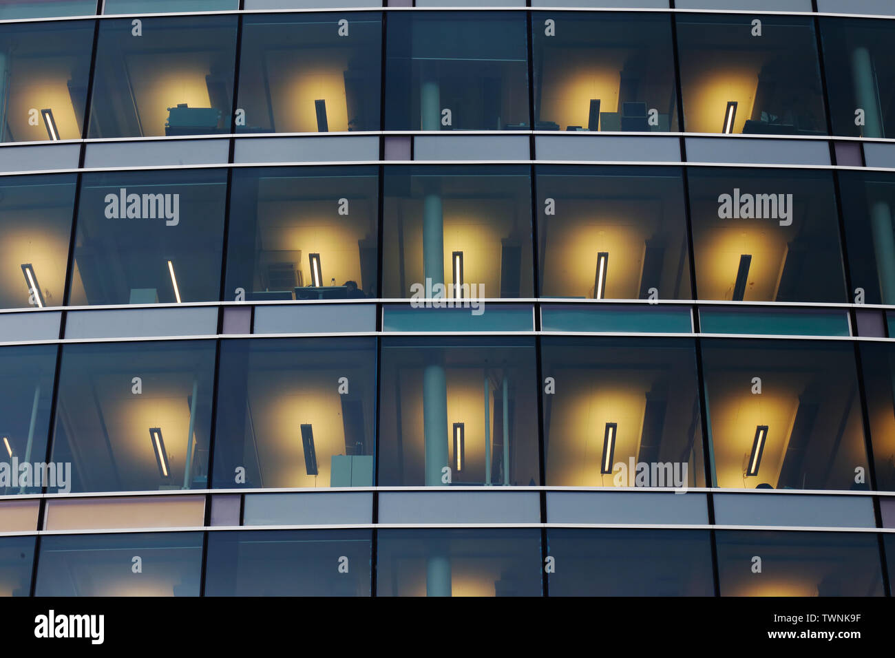Low Angle View eines modernen Bürogebäudes mit Leuchtstofflampen im Innenbereich. Stockfoto