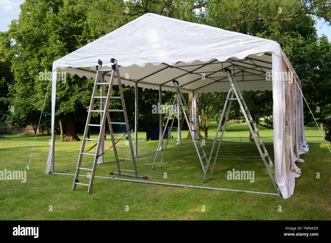 Event Zelt mit Leitern auf dem Rasen in einem Park für einen Sommer Party oder Hochzeit Set Stockfoto