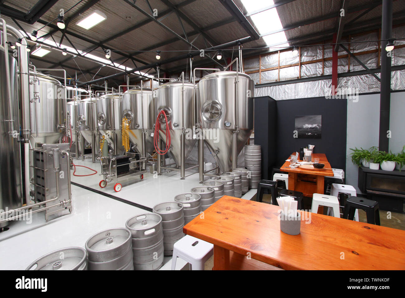 Stahltanks mit Esstischen im Vordergrund in der Handwerk Bier Brauerei cotts" in Oamaru, Neuseeland Stockfoto