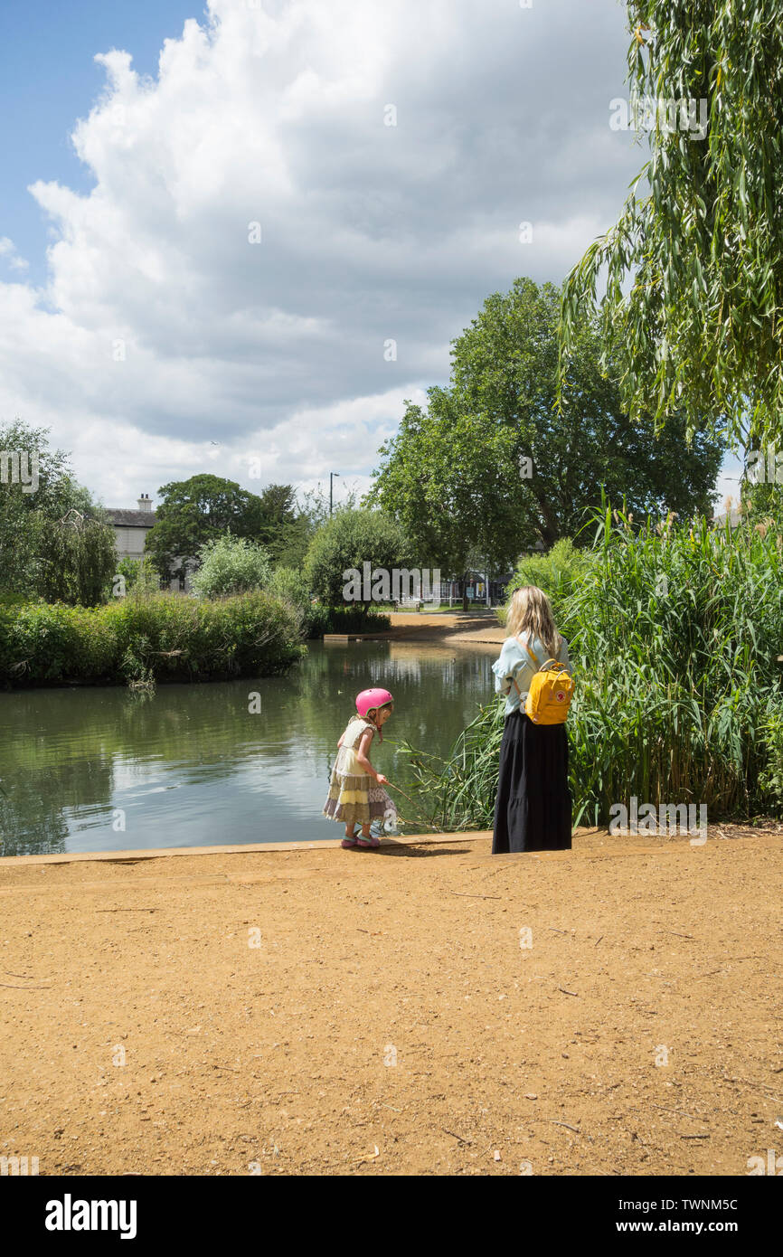 Eine Mutter und Tochter Beobachten der Enten zusammen Neben Barnes Teich, London, SW13, Großbritannien Stockfoto