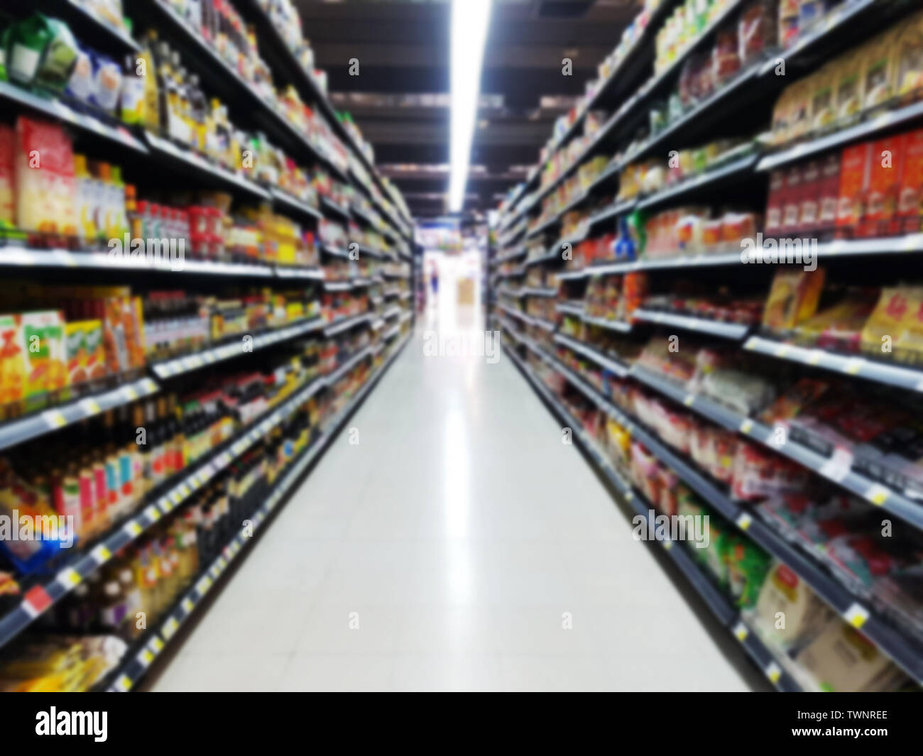 Abstrakte verschwommen Supermarkt Gang mit bunten Waren auf den Regalen mit verschwommenen Kunden Kassierer für Hintergrund Stockfoto