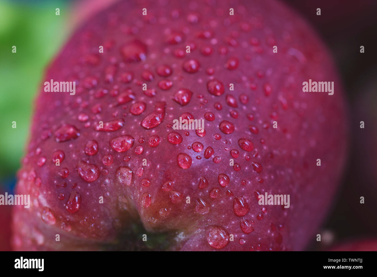 Wassertropfen auf einem roten Apfel Hintergrund Stockfoto