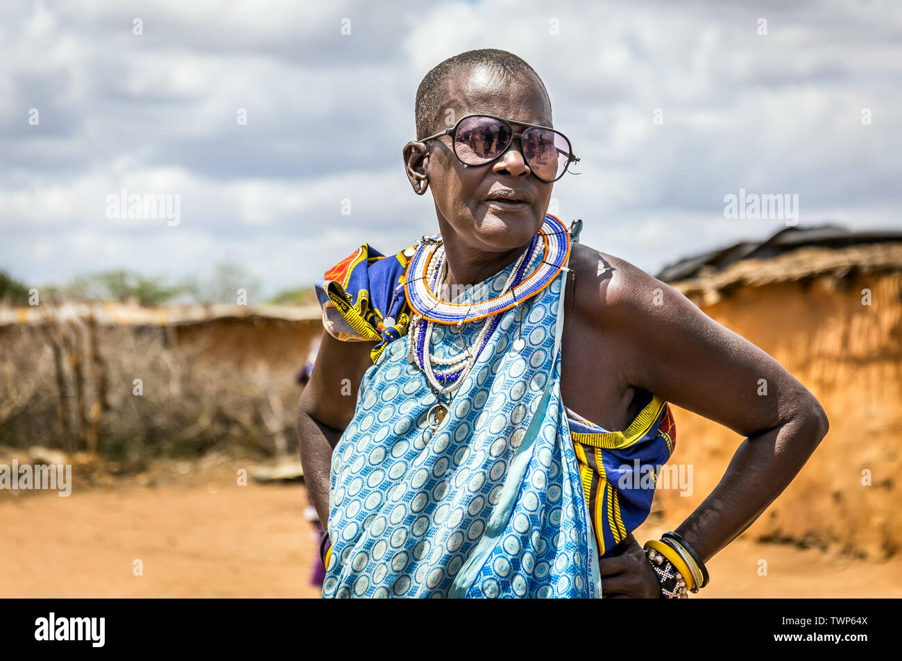 MASAI DORF, KENIA - Oktober 11, 2018: Unindentified afrikanischen älteren Frau, die traditionelle Kleidung und große Gläser in Masai Stamm, Kenia Stockfoto