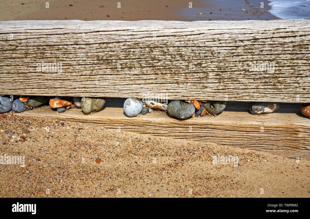 Steine eingekeilt zwischen Hölzern in Holz- Mole an der Küste von Norfolk auf Warenkorb Lücke, Happisburgh, Norfolk, England, Vereinigtes Königreich, Europa. Stockfoto