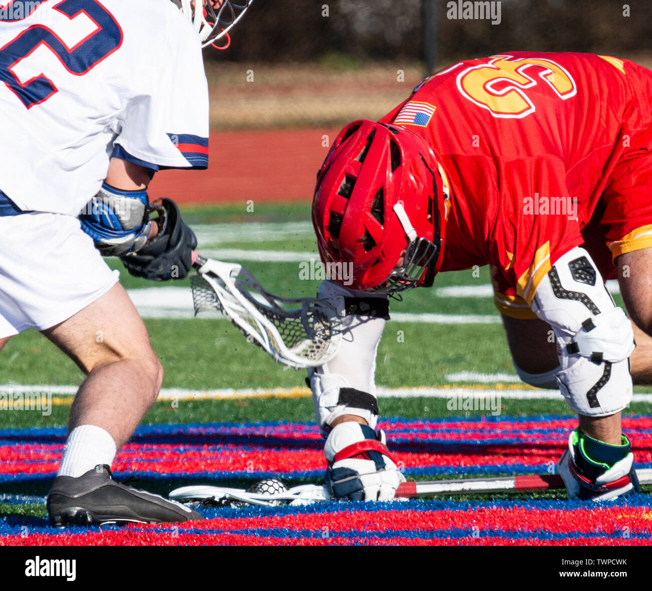 Zwei High School lacrosse Spieler kämpfen um den Ball bei einem Gesicht weg und man hat den Ball in der Verrechnung der seinen Stock gefangen. Stockfoto