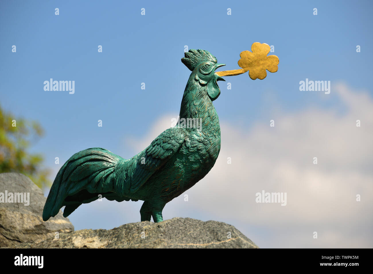 Die Bronzestatue von ein Hahn mit goldenen Kleeblatt im Schnabel. Sehenswürdigkeiten in Hahnenklee, ein Urlaubsziel im Harz, Deutschland. Stockfoto