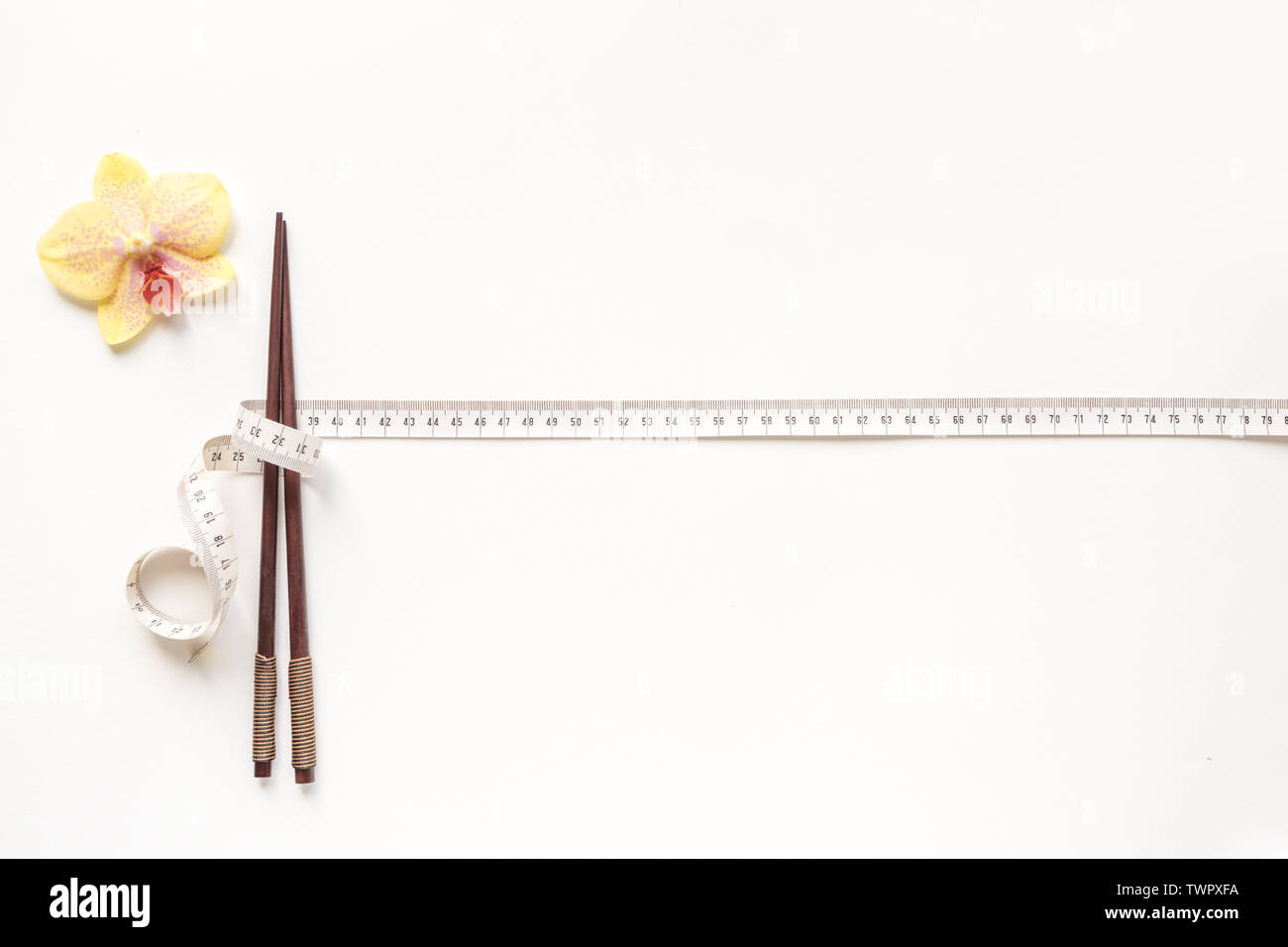 Asiatischen Ernährung Konzept. Stäbchen und Maßband auf weißem Hintergrund, kopieren. Diät, asiatische gesunder Lebensstil, Gewichtsverlust Konzept. Stockfoto