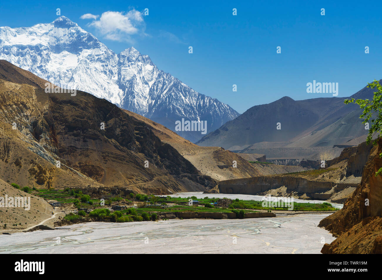 Aus der Distanz betrachtet, alten Dorf von Chuksang in der Kali Gandaki Tal, Upper Mustang, Nepal. Nilgiri Norden (7061 m) im Hintergrund. Stockfoto