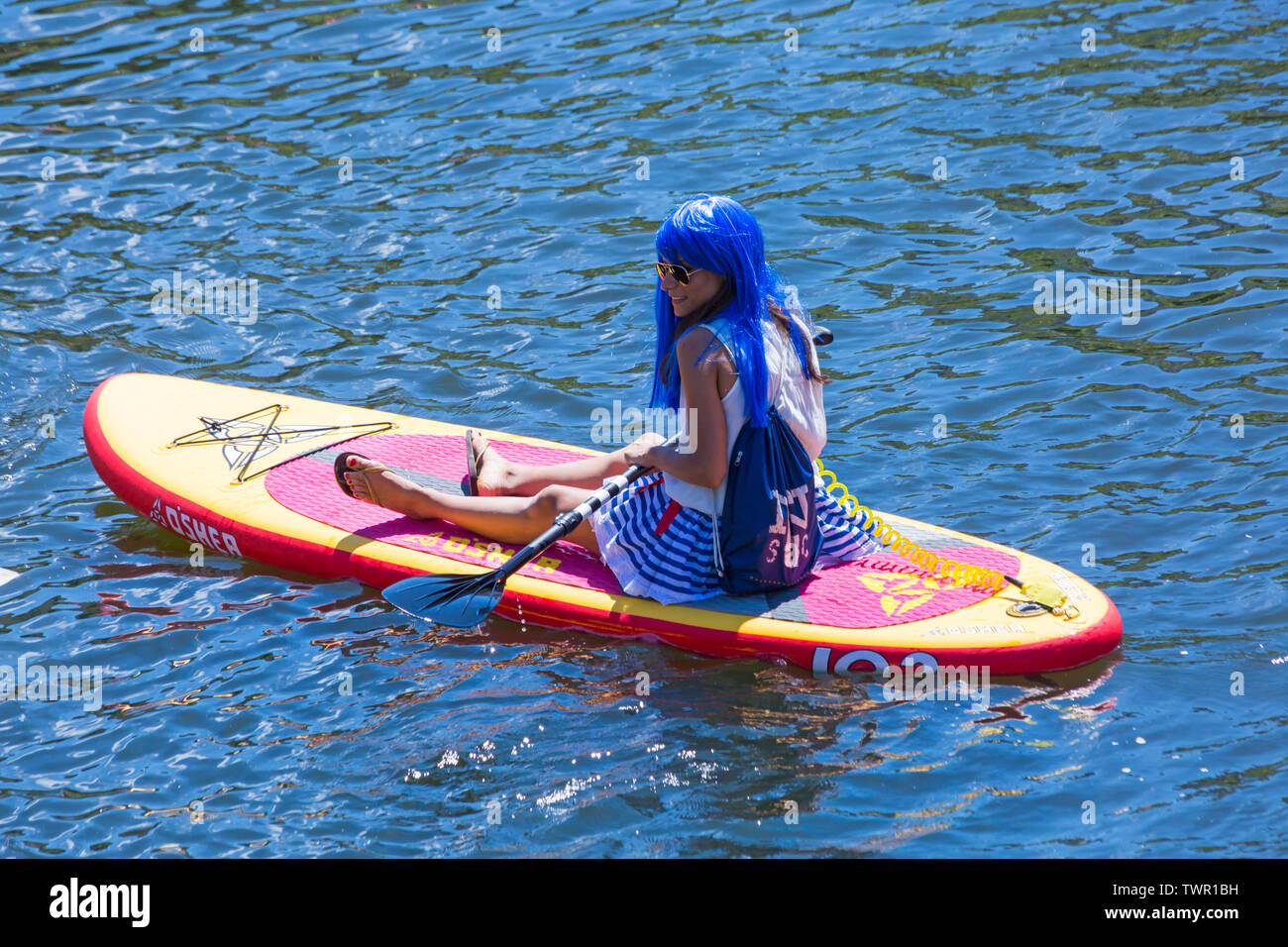 Iford, Dorset, Großbritannien. Am 22. Juni 2019. Perfektes Wetter, warm und sonnig, noch für Dorset Beiboot Tag mit Hunderten von Schlauchboote, Faltboote, Handwerk, Platten bilden eine Flottille Segeln von iford Brücke, den Fluss Stour zu Tuckton Brücke. Die Veranstaltung begann im Jahr 2014 als ein wenig Spaß, aber hat jetzt eine jährliche Veranstaltung Geld für Nächstenliebe und Getter jedes Jahr größer geworden. Frau mit langen blauen Haare sitzen entspannt auf O'Shea Aufblasbare paddleboard paddle Board aufblasbare SUP. Credit: Carolyn Jenkins/Alamy leben Nachrichten Stockfoto