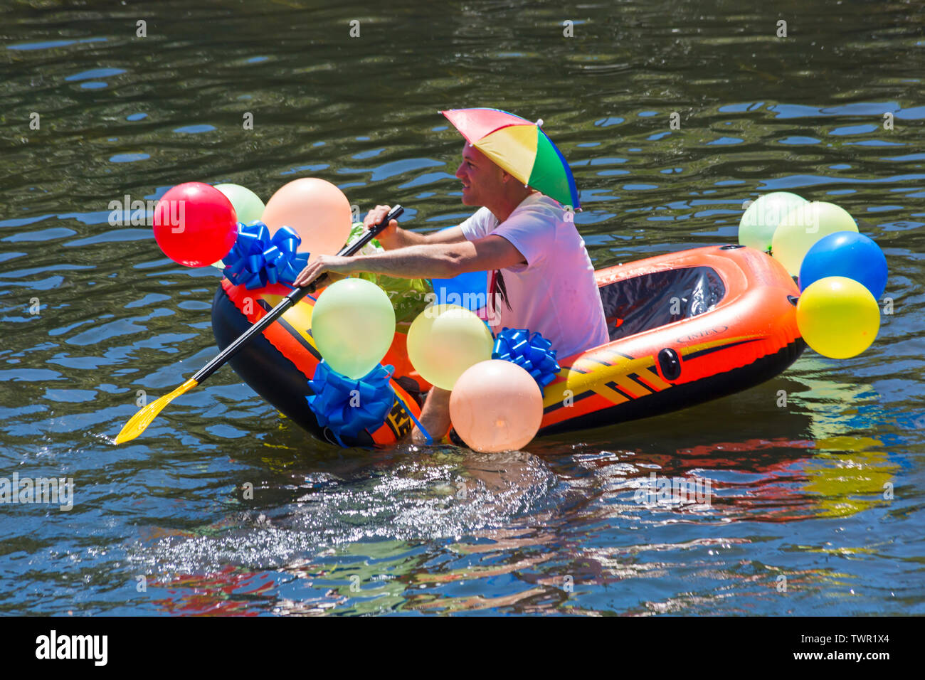 Iford, Dorset, Großbritannien. Am 22. Juni 2019. Perfektes Wetter, warm und sonnig, noch für Dorset Beiboot Tag mit Hunderten von Schlauchboote, Faltboote, Handwerk, Platten bilden eine Flottille Segeln von iford Brücke, den Fluss Stour zu Tuckton Brücke. Die Veranstaltung begann im Jahr 2014 als ein wenig Spaß, aber hat jetzt eine jährliche Veranstaltung Geld für Nächstenliebe und Getter jedes Jahr größer geworden. Mann Spaß im Beiboot mit Ballons und tragende Dach hat. Credit: Carolyn Jenkins/Alamy leben Nachrichten Stockfoto