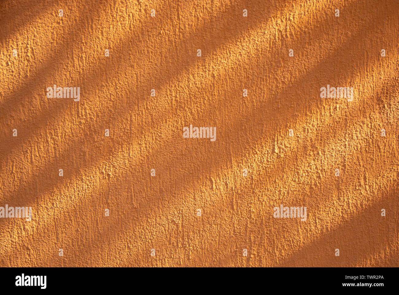Orangefarbene rauhe Wand Textur mit diagonal Schatten. Stockfoto