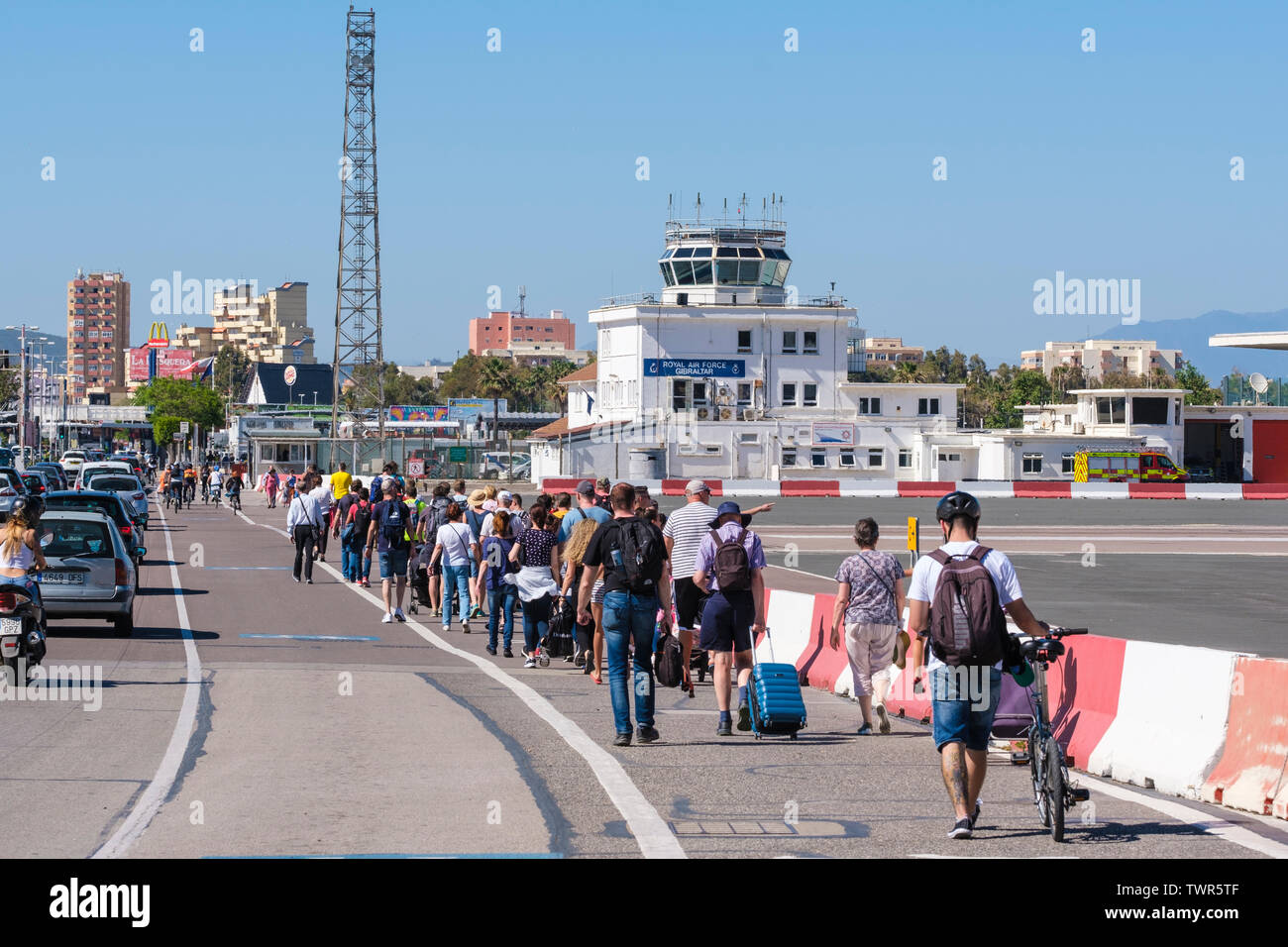 Der internationale Flughafen von Gibraltar Auftragsbestand von Fußgängern und Fahrzeugen als Straße öffnet sich über Start- und Landebahn nach Flugzeug nimmt. Stockfoto