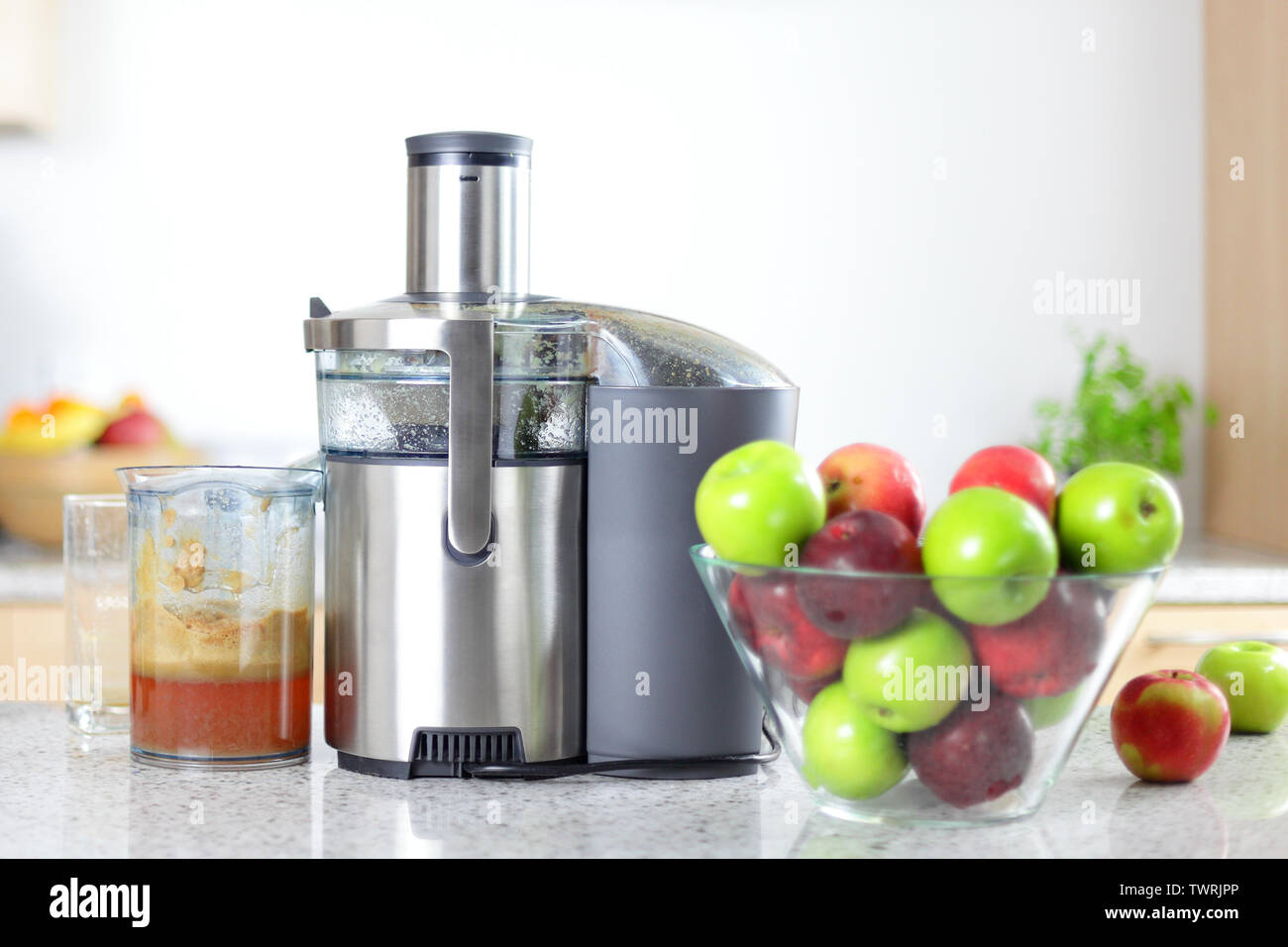 Apfelsaft auf Entsafter entsaften Maschine-Konzept. Äpfel in Schale in  kitching und frisch gepressten Saft Stockfotografie - Alamy