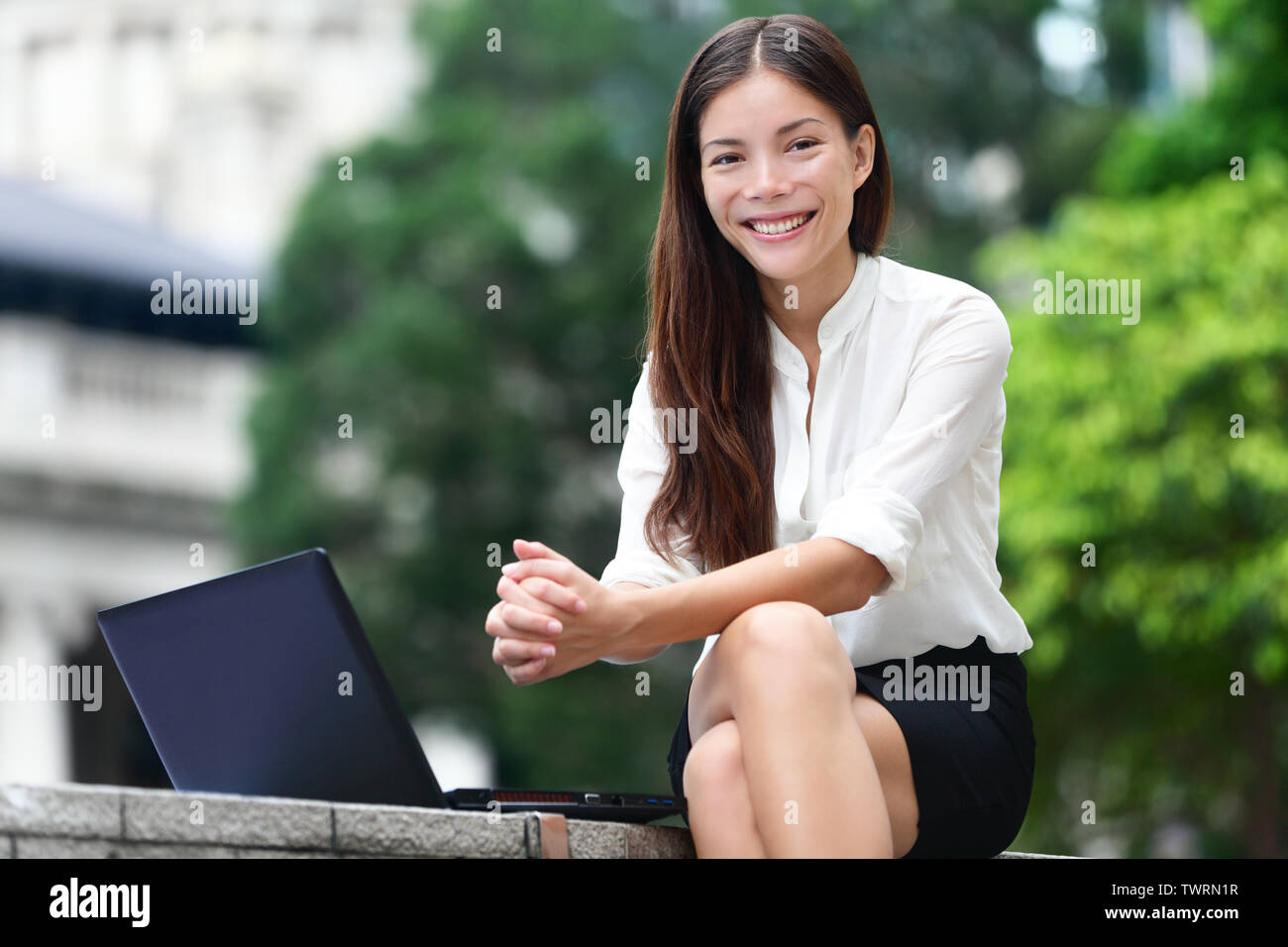 Geschäft Leute - die Frau, die auf dem Laptop in Hongkong. Geschäftsfrau auf Computer und Internet außerhalb im Zentrum von Hong Kong. Junge weibliche Professional Business Frau lächelnd. Asiatische Chinesische kaukasische Frau. Stockfoto