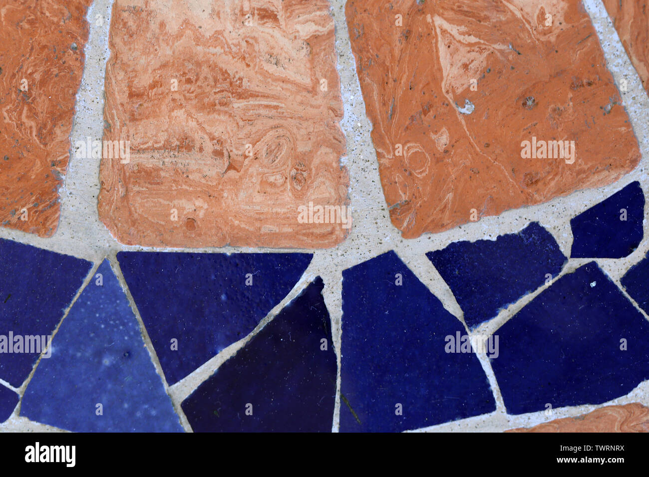 Textur der Fußboden aus Orange und Blau Stück von Fliesen. Es gibt auch einige Graue Zement dazwischen. Schöne bunte Oberfläche! Stockfoto